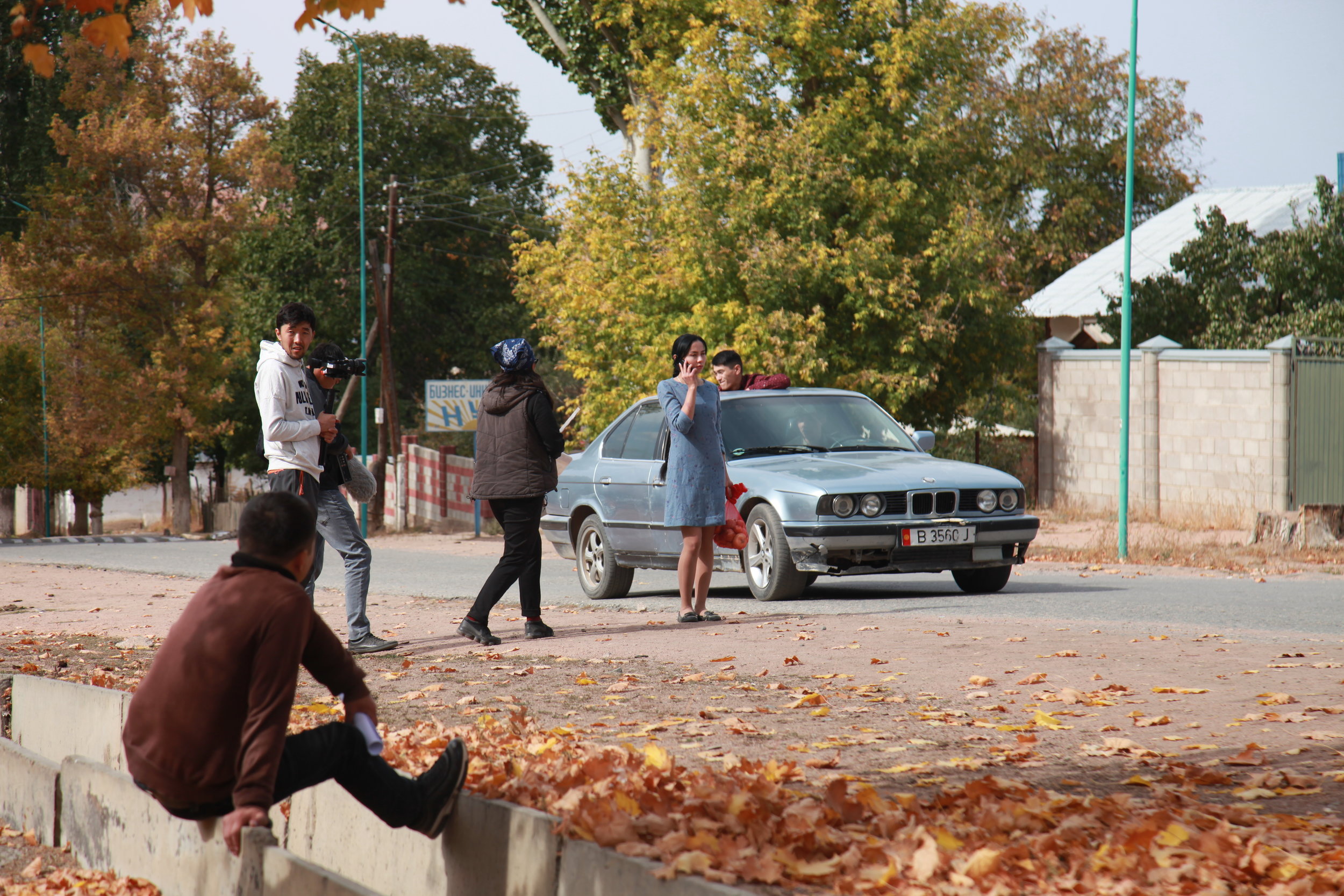 On set: Mira, played by Anara Taalaybek Kyzy, talks on the phone as a car draws up behind her